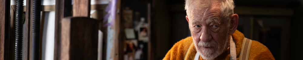 man with white beard and orange jumper looks up to no good