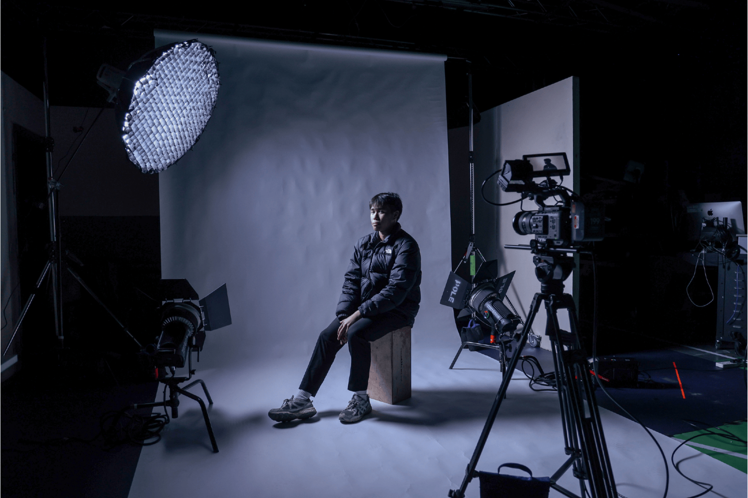 Man sits on stool to demonstrate film set up for music video