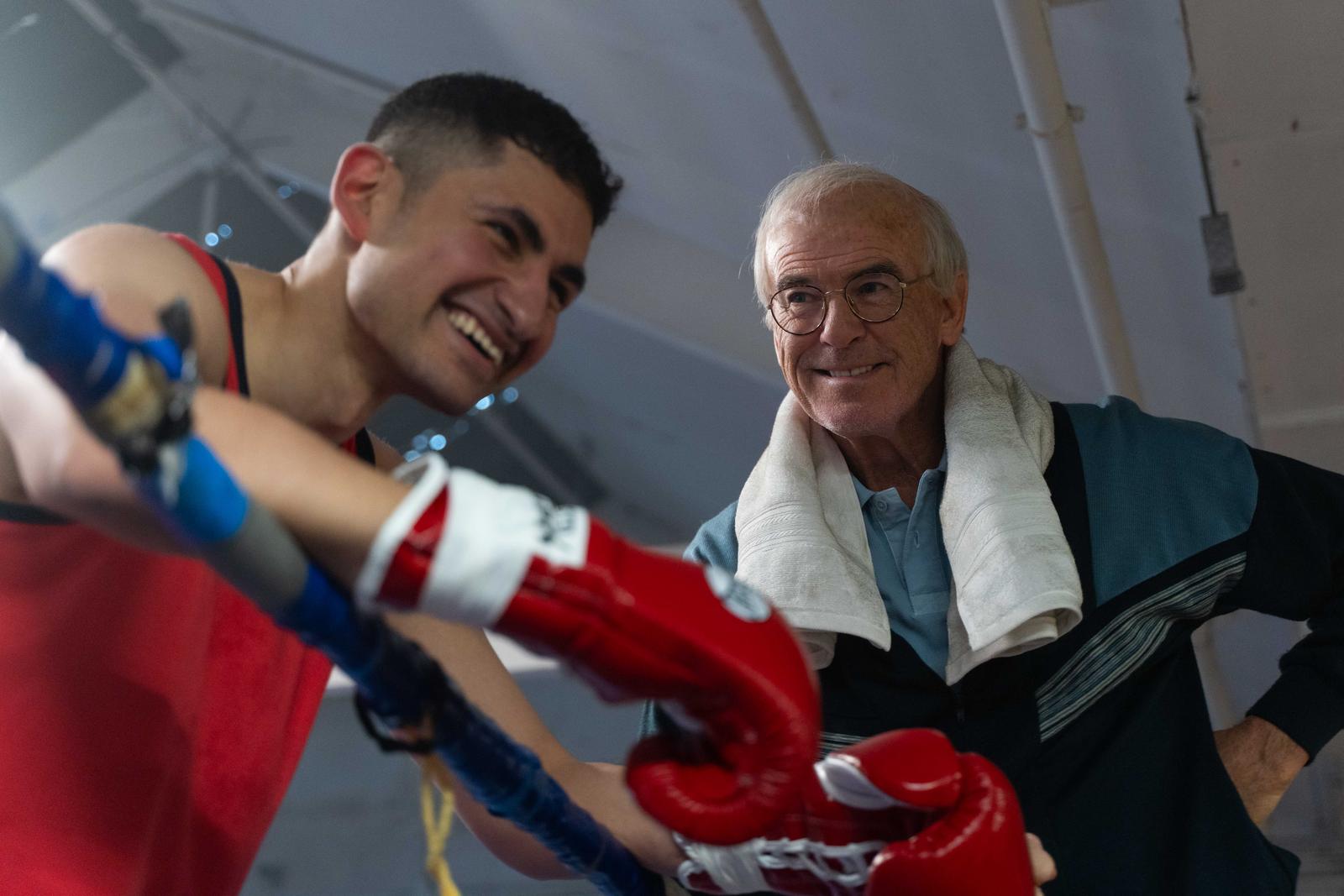 two men in a boxing ring smile